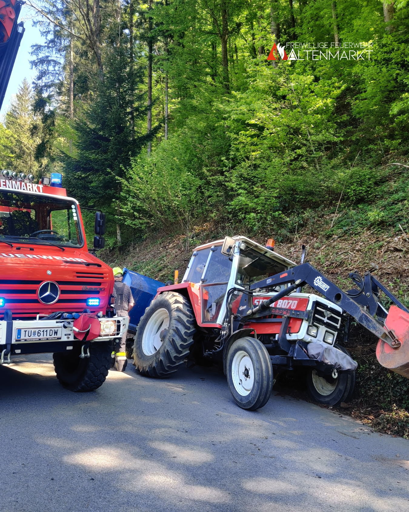 Traktor in Schieflage im Straßengraben und Feuerwehrauto von vorne
