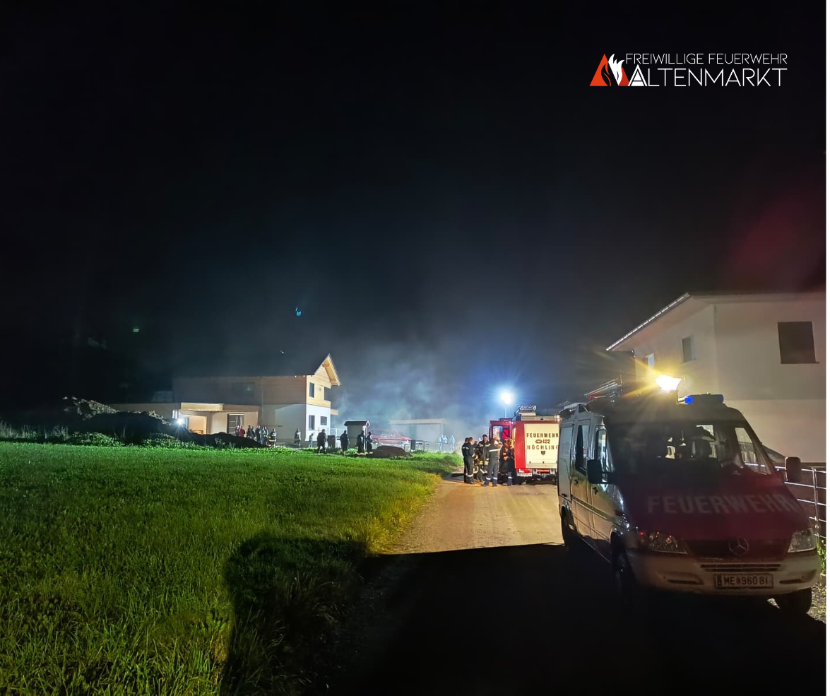 Feuerwehrautos vor Gebäude aus dem Rauch austritt