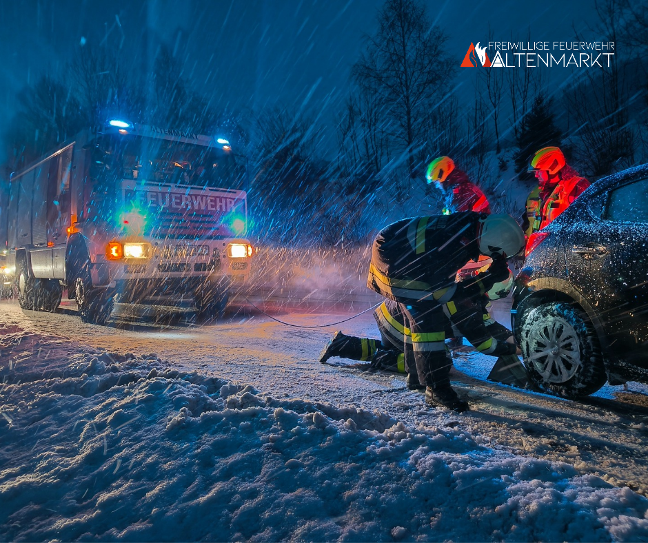 PKW und Feuerwehrauto auf Schneefahrbahn mit Einsatzkräften