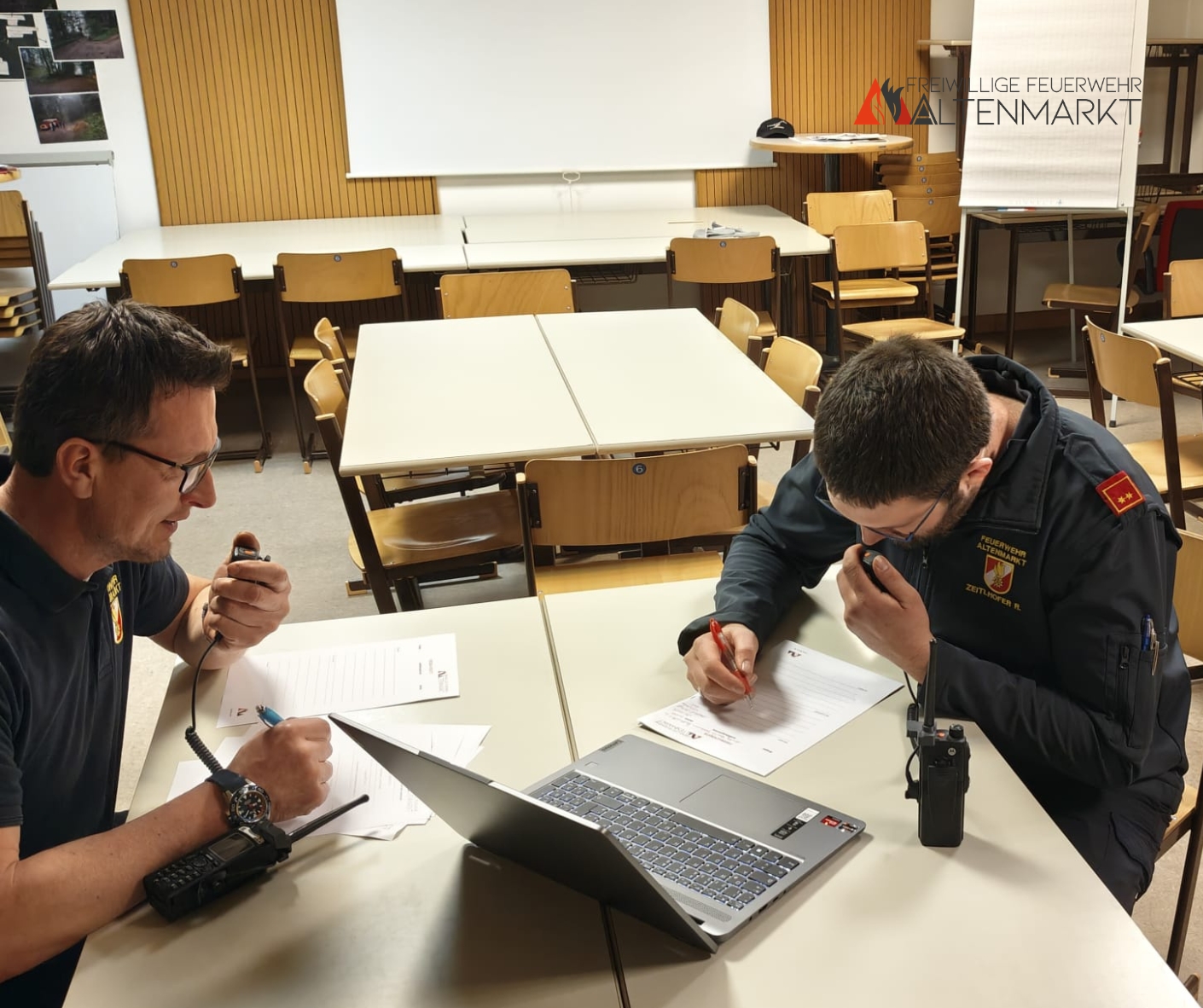 Zwei Feuerwehrmänner beim Bedienen der Funkgeräte.