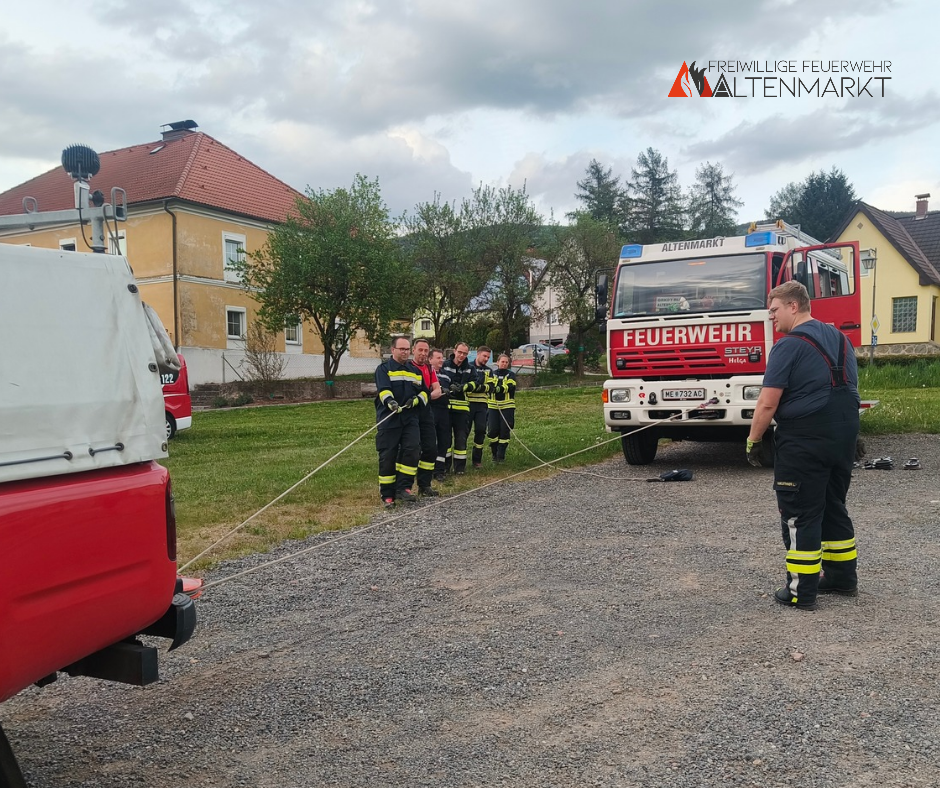 Feuerwehrmitglieder beim Ziehen eines Fahrzeuges